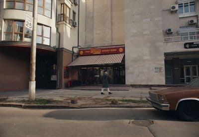 a person walking down the street in front of a building