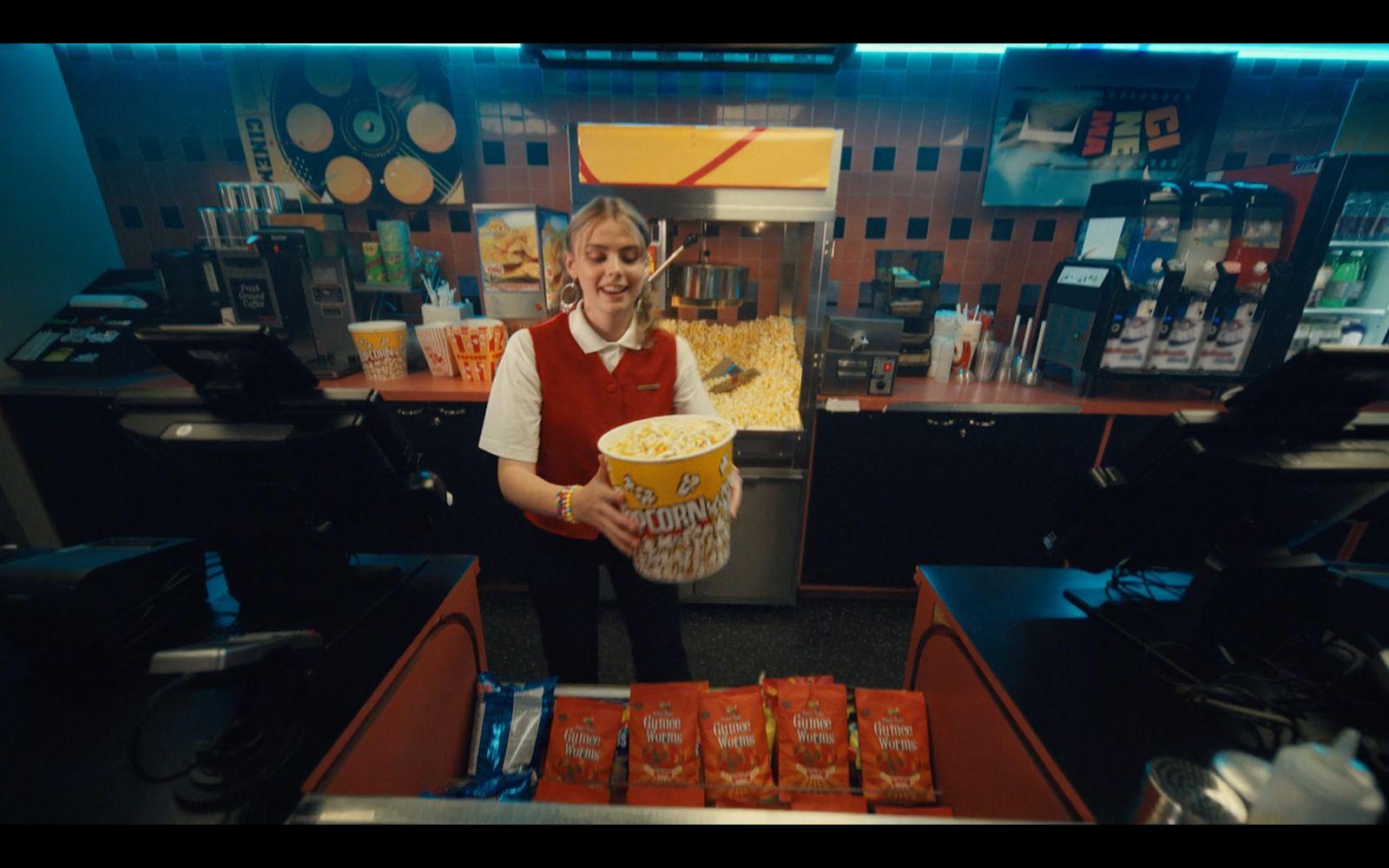 a man holding a bucket of food in front of a counter