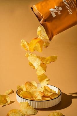a bag of chips falling into a bowl of chips