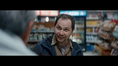 a man is talking to another man in a store