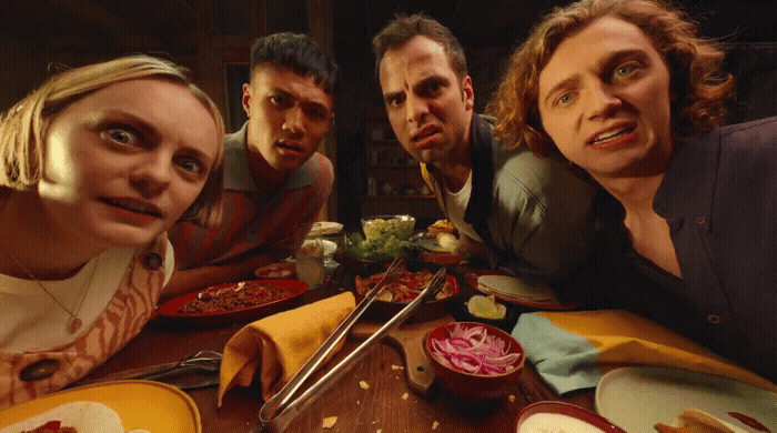 a group of people sitting around a table eating food