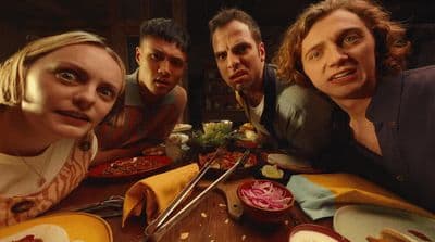 a group of people sitting around a table eating food
