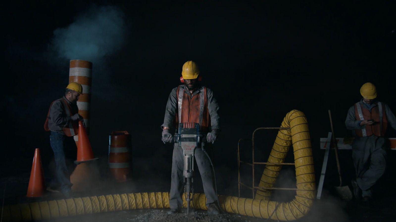 a group of men standing around a yellow pipe