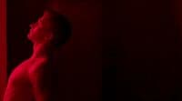 a man standing in front of a red light