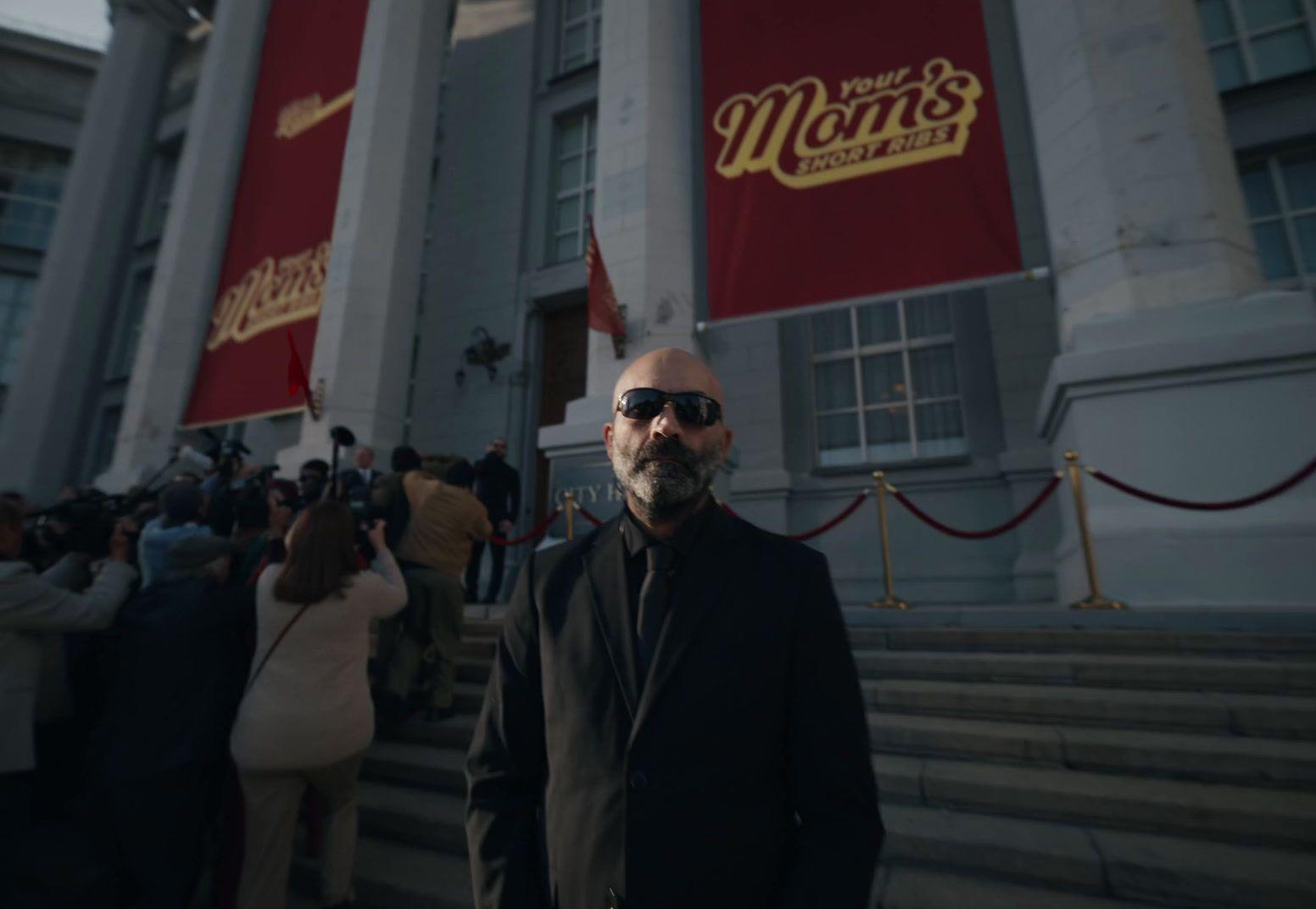 a man in sunglasses standing in front of a building