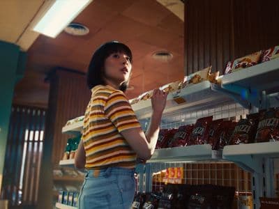 a woman standing in front of a shelf of candy