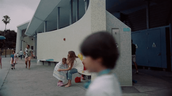 a group of people sitting on a bench in front of a building