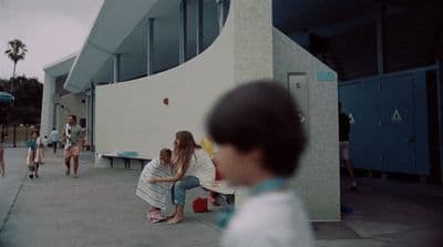 a group of people sitting on a bench in front of a building