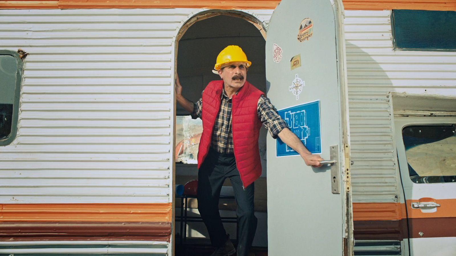 a man in a hard hat standing in a doorway of a trailer