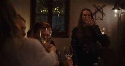 a group of people sitting around a table drinking wine