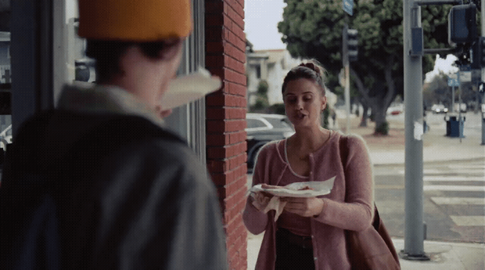 a woman standing next to a man holding a plate of food