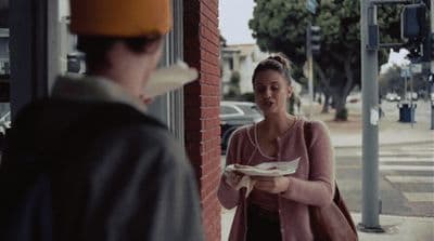 a woman standing next to a man holding a plate of food