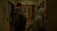 a couple of people walking down a hallway