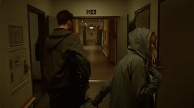 a couple of people walking down a hallway