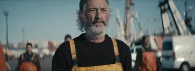 a man with a beard wearing overalls and a sweater