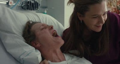 a woman laying in a hospital bed next to a woman
