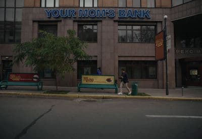 a couple of people walking past a bank