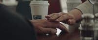 a couple of people holding hands over a table