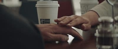 a couple of people holding hands over a table