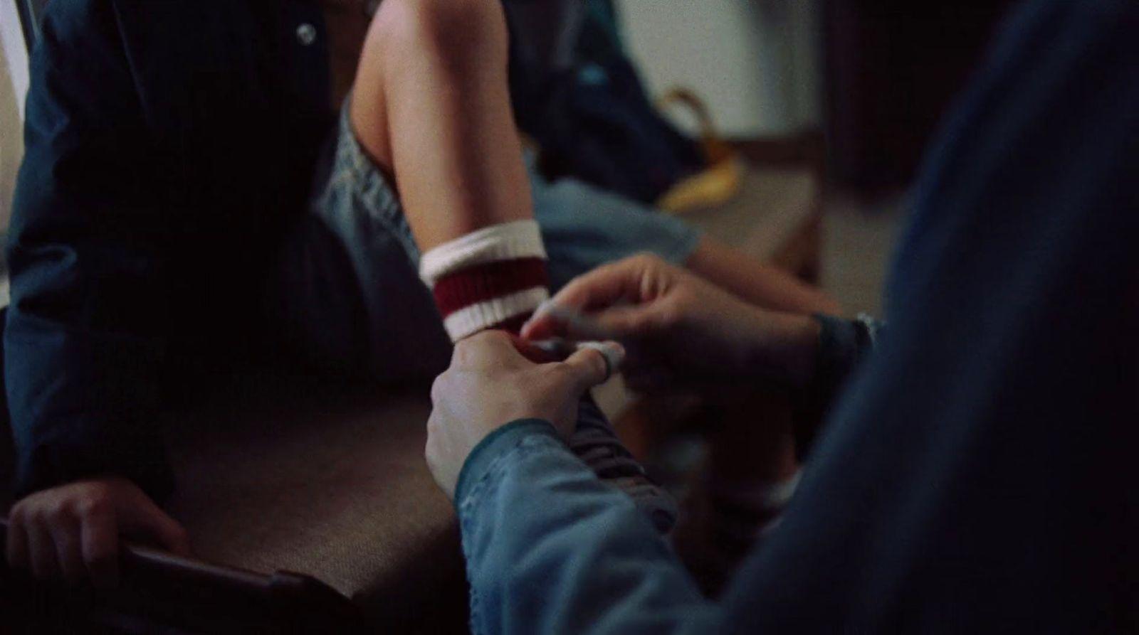a person sitting on a couch holding a cigarette