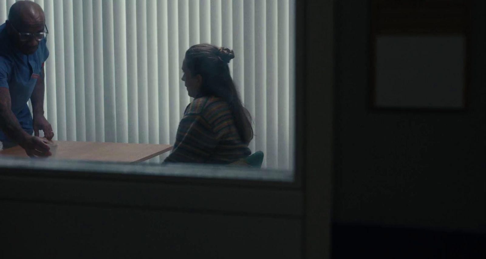 a man standing next to a woman sitting at a table