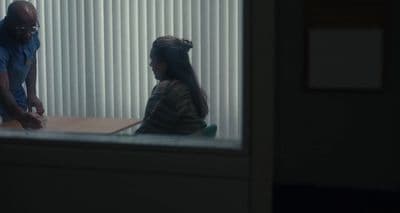 a man standing next to a woman sitting at a table