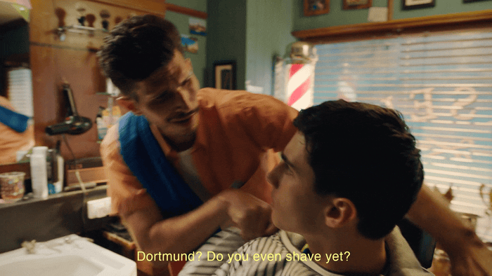 a man cutting another man's hair in a barber shop