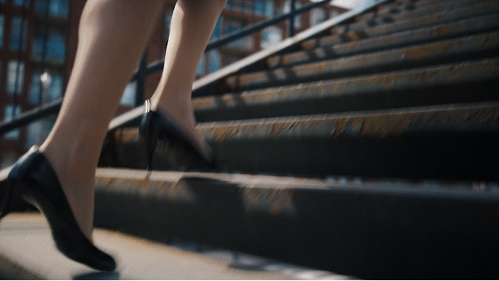 a woman in high heels walking down a flight of stairs