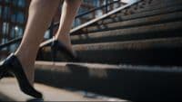a woman in high heels walking down a flight of stairs