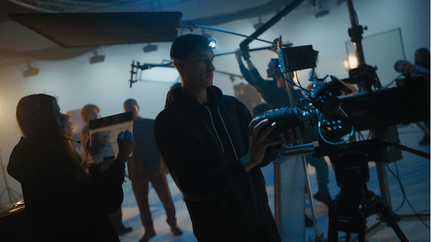 a group of people standing around a camera