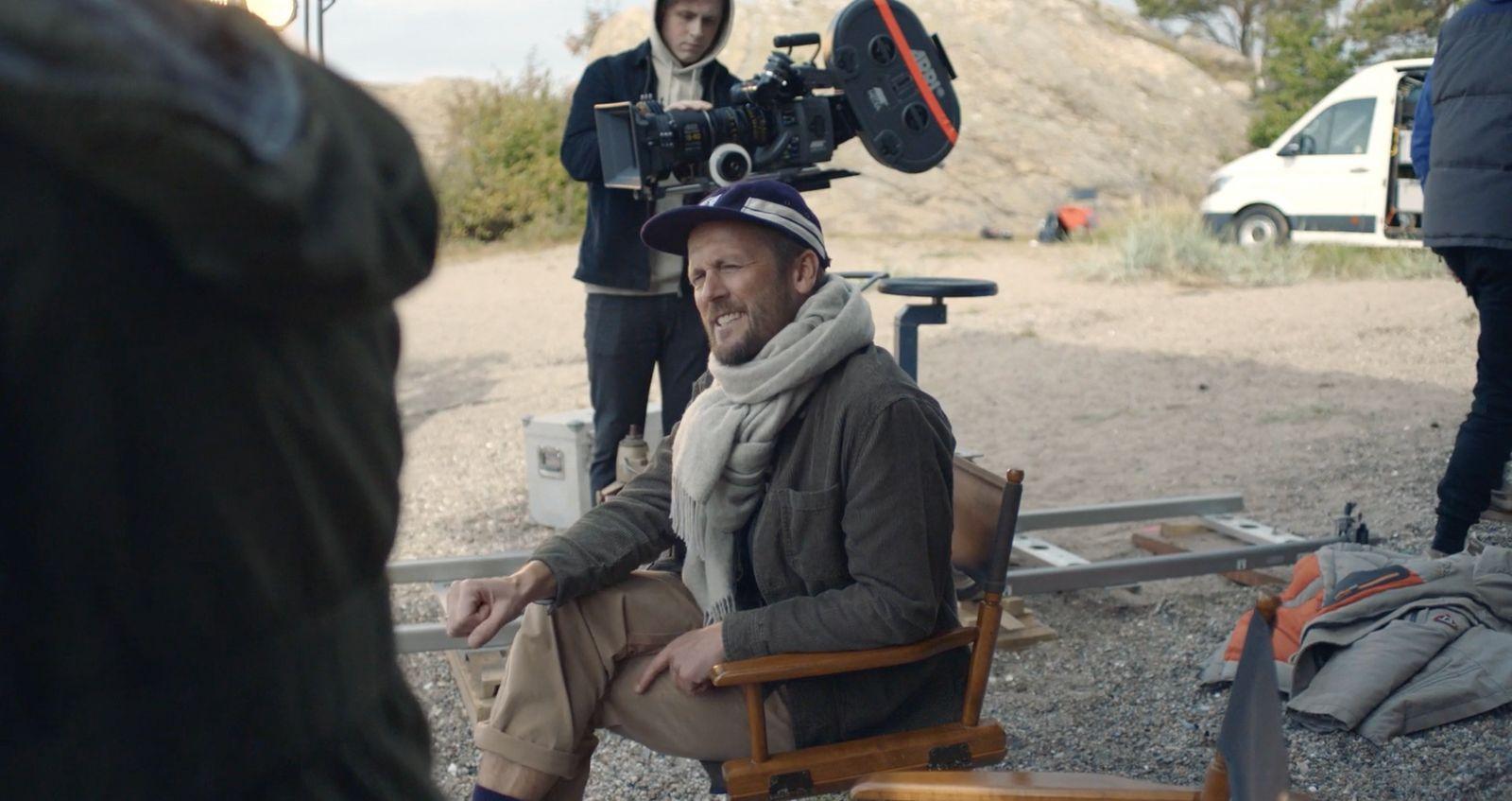 a man sitting in a chair in front of a camera
