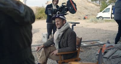 a man sitting in a chair in front of a camera