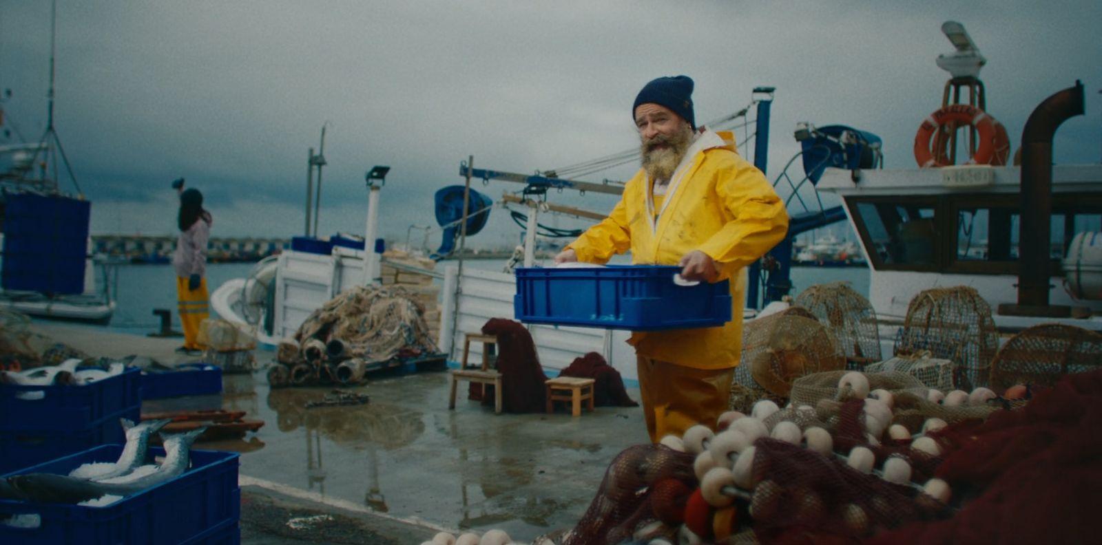 a man in a yellow raincoat holding a blue bucket