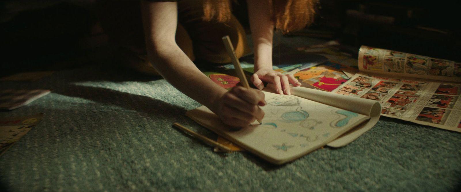 a person is writing on a notebook with a pen