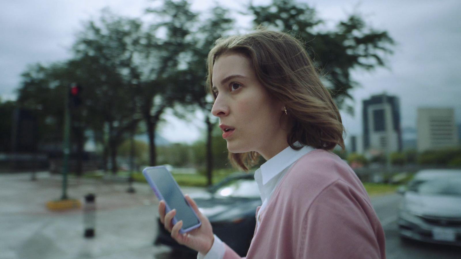 a woman in a pink shirt is holding a tablet