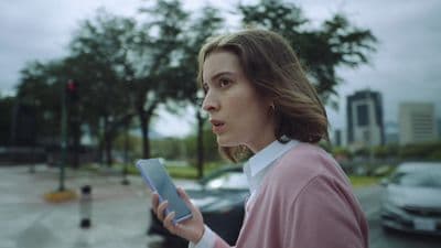 a woman in a pink shirt is holding a tablet