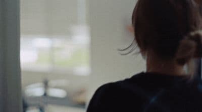 a woman standing in front of a window