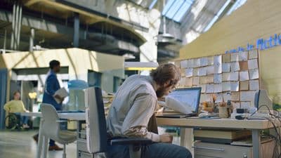 a man sitting at a desk working on a laptop
