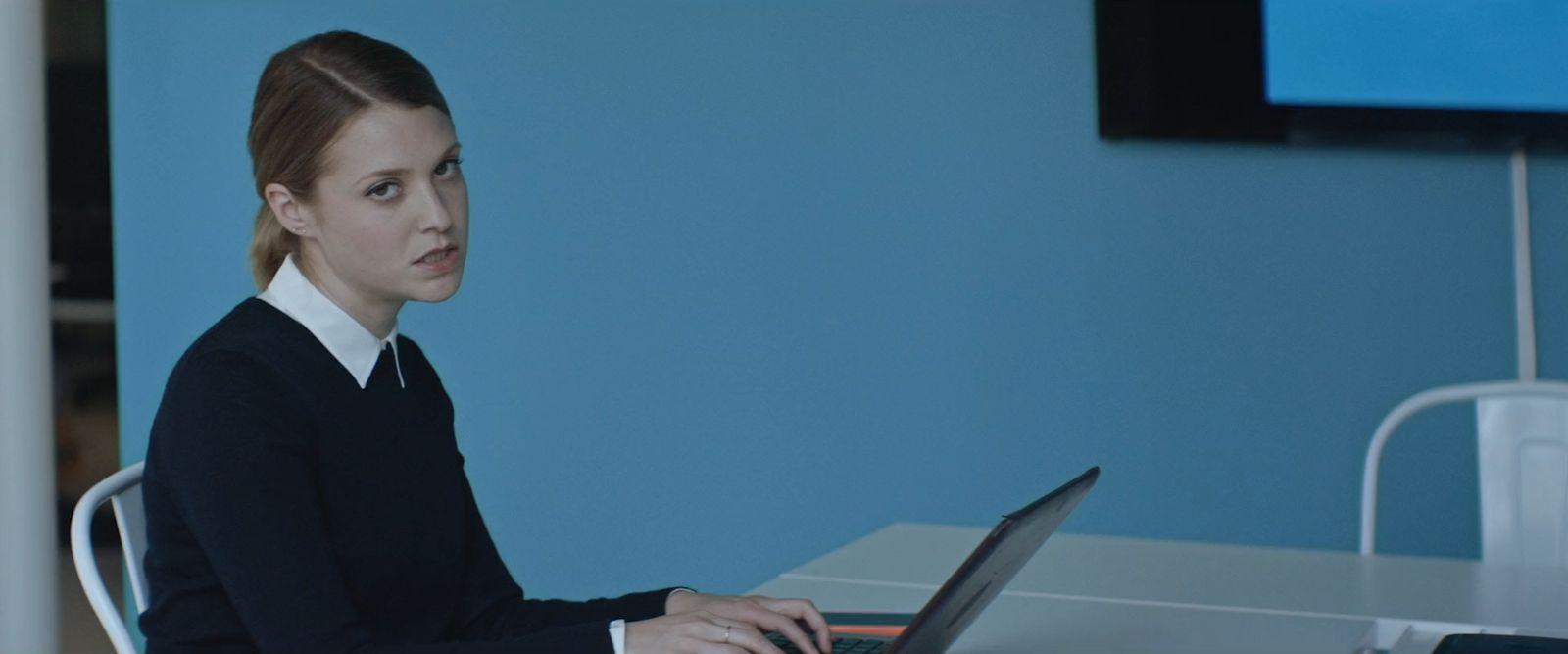 a woman sitting at a table using a laptop computer