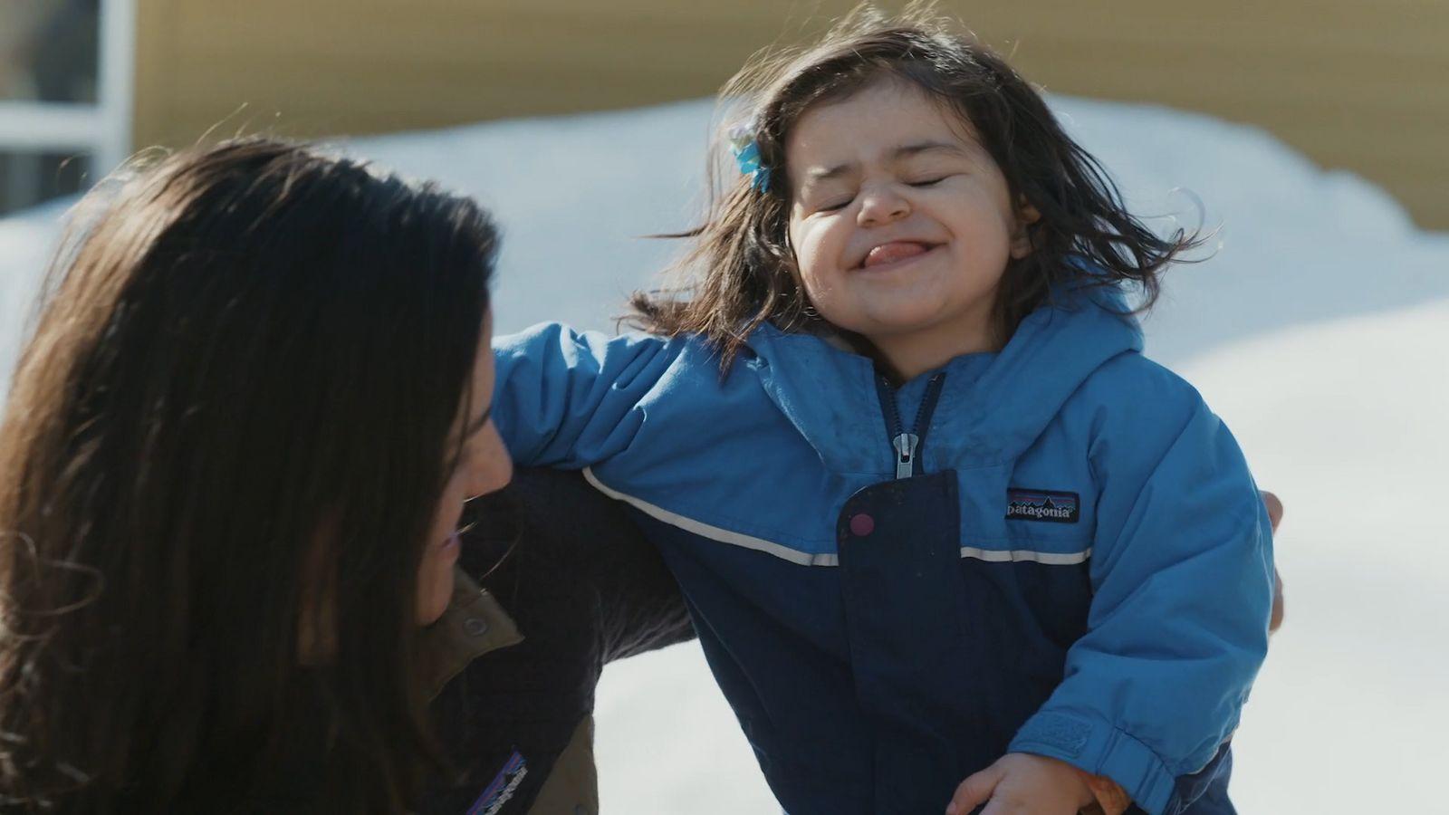a woman holding a little girl in her arms