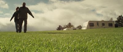 a man and a woman walking through a field