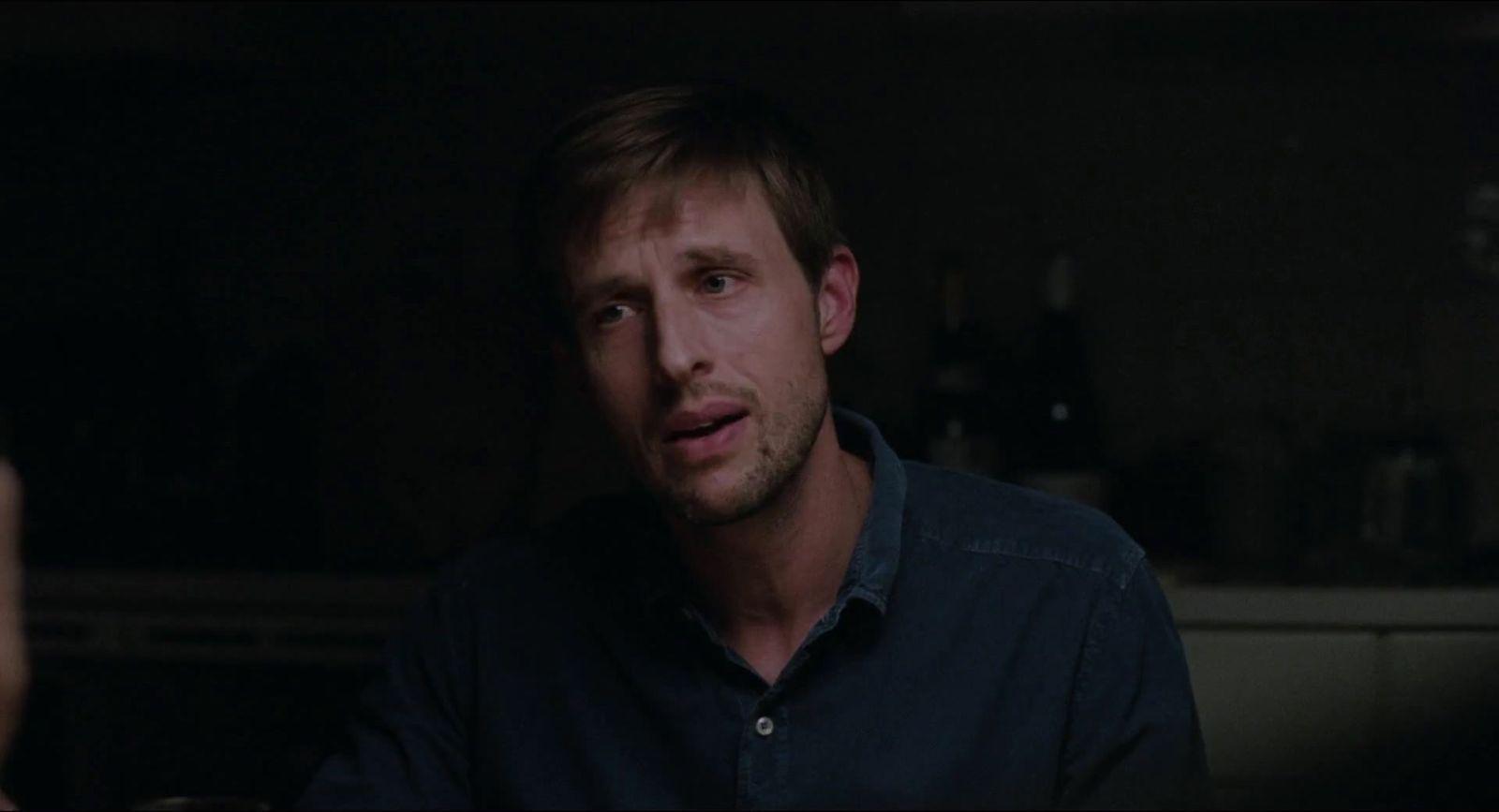 a man in a dark room looking at the camera
