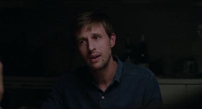 a man in a dark room looking at the camera