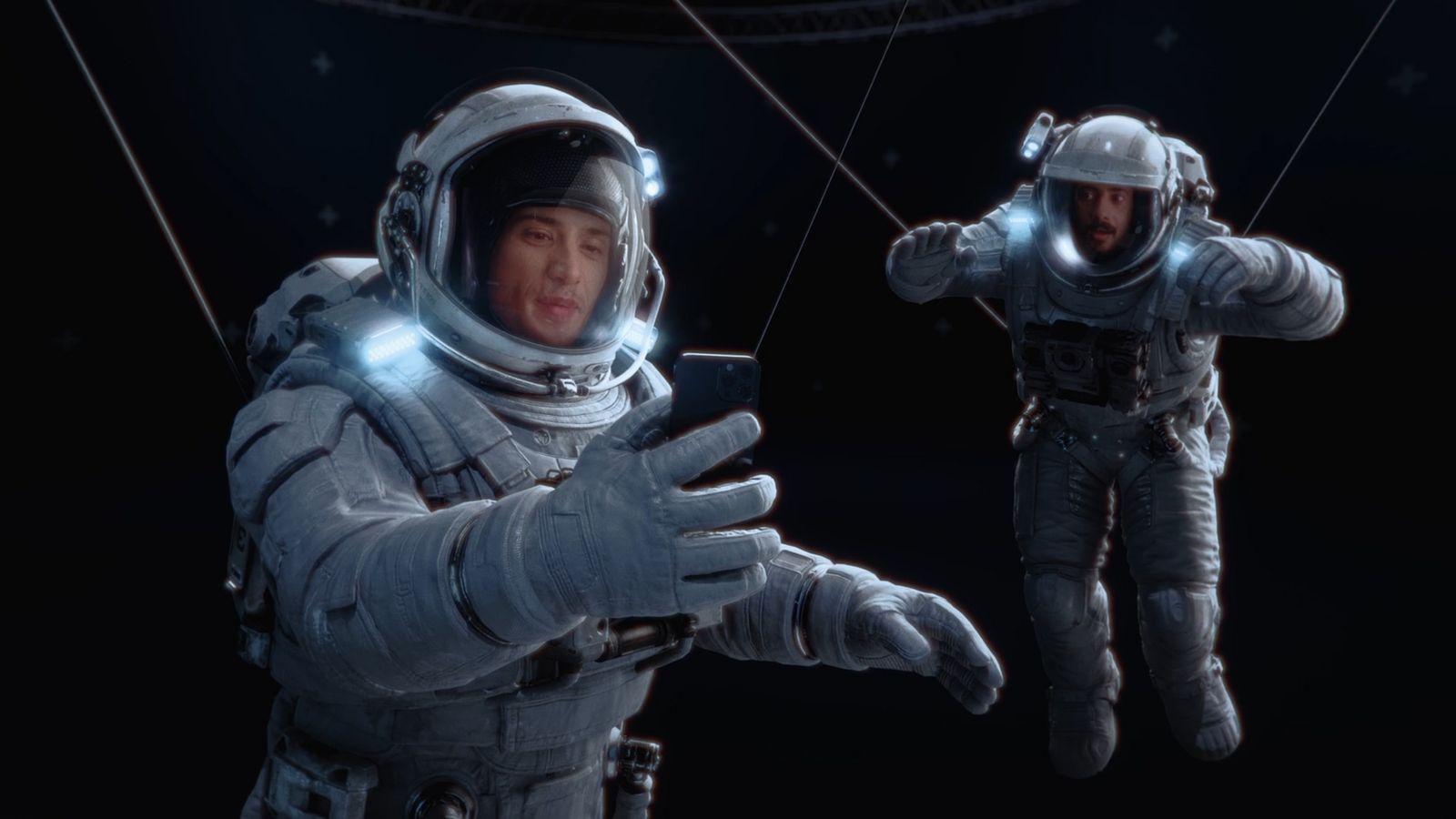 a man in a space suit holding a cell phone