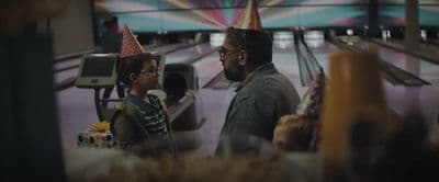 a man standing next to a little girl wearing a birthday hat