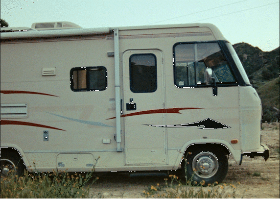 an rv parked on a dirt road in the desert