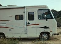 an rv parked on a dirt road in the desert