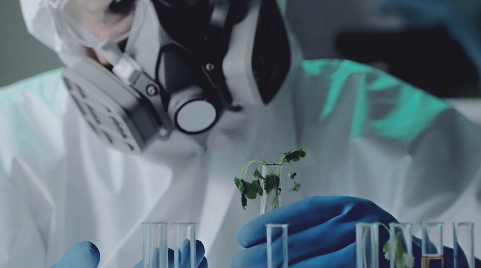 a person in a white coat and blue gloves
