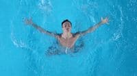 a man swimming in a pool with his arms outstretched