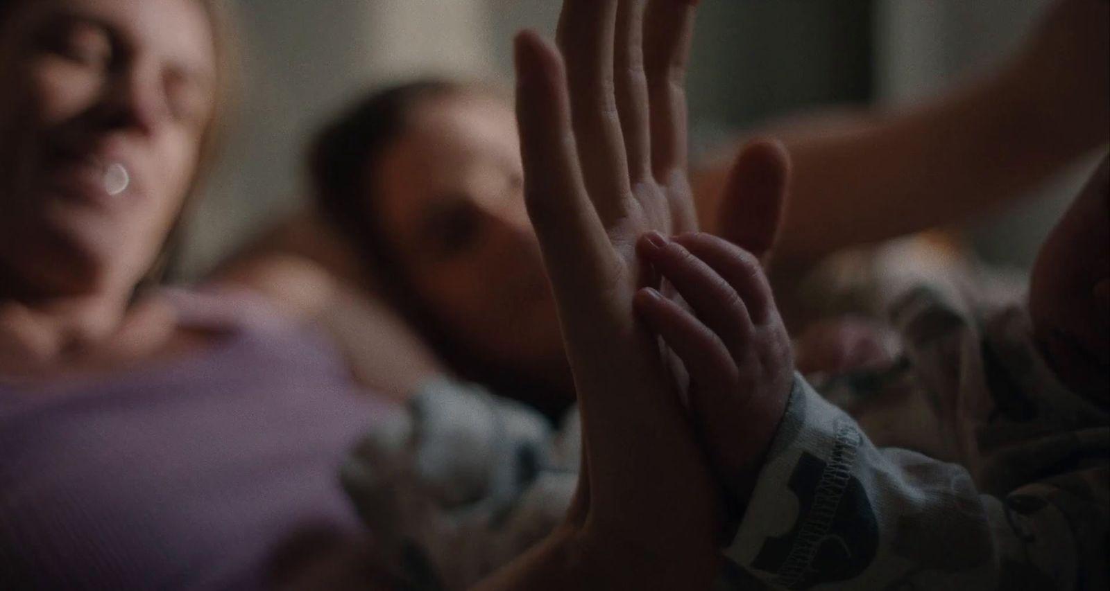 a woman laying in bed with a baby in her arms